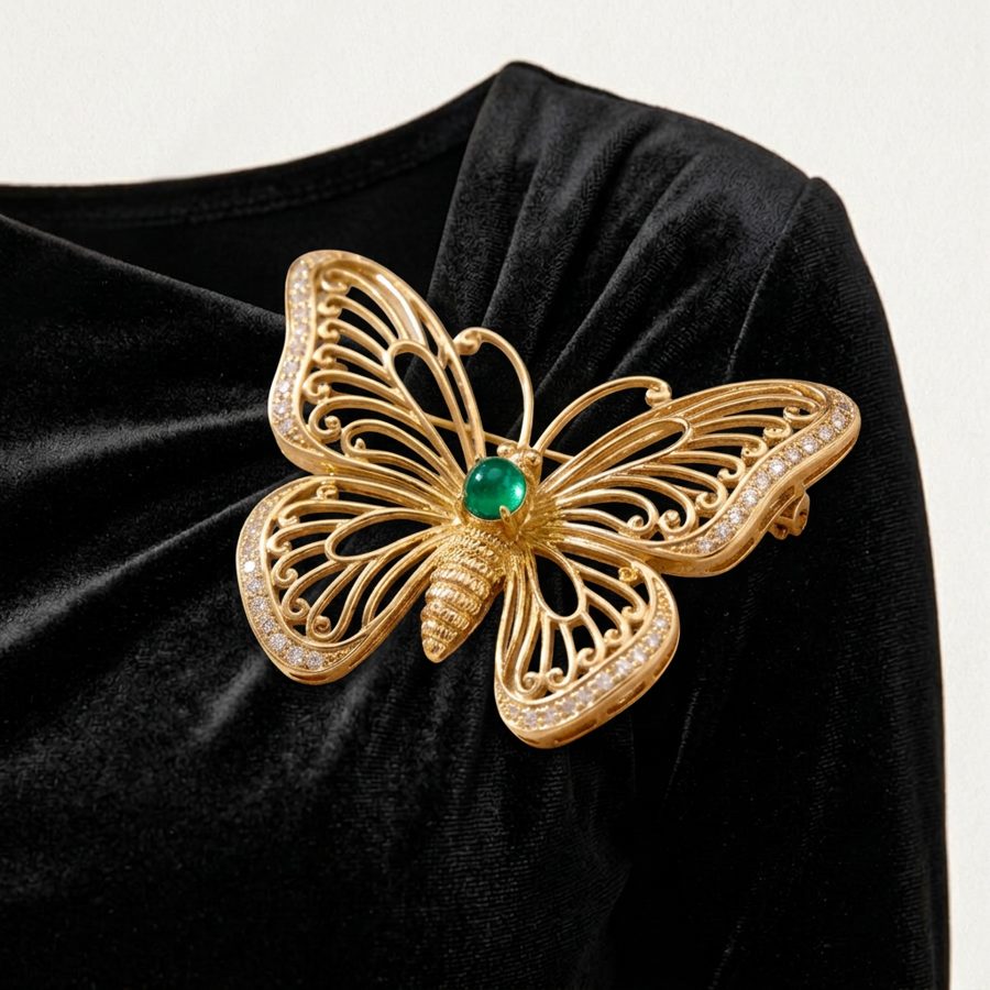 Broche mariposa dorado prendido sobre el drapeado del vestido negro